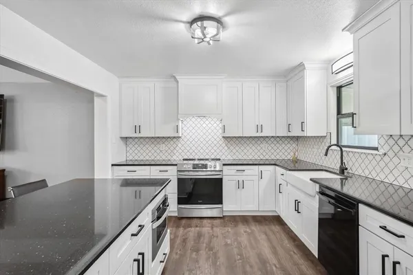 a kitchen with stainless steel appliances granite countertop a sink stove and cabinets