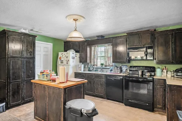 a kitchen with granite countertop stainless steel appliances a sink stove and refrigerator
