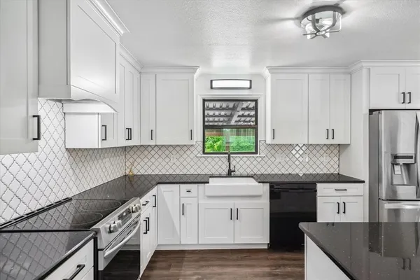 a kitchen with granite countertop a sink stainless steel appliances and cabinets