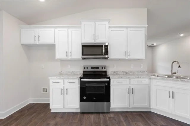 a kitchen with stainless steel appliances granite countertop a stove and a wooden cabinets
