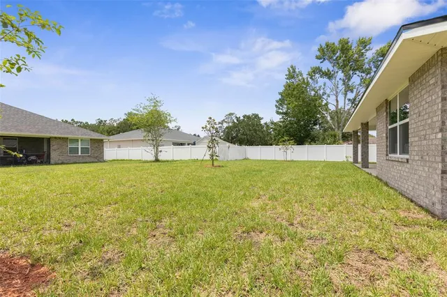 a backyard of a house with lots of green space and fountain