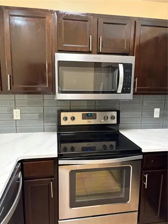 a kitchen with wooden cabinets and a stove top oven