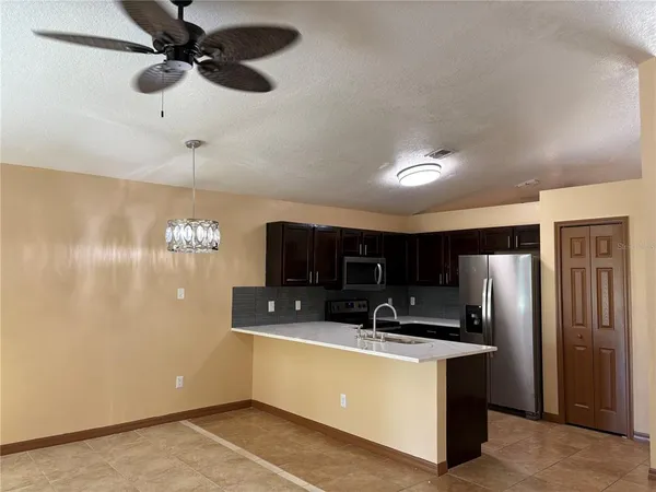 a kitchen with kitchen island a counter top space stainless steel appliances and cabinets