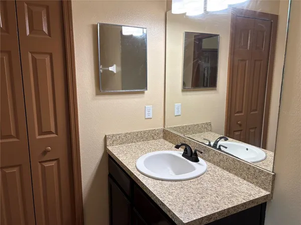 a bathroom with a granite countertop sink and a mirror