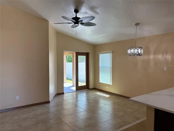 a view of an empty room with window and cabinet