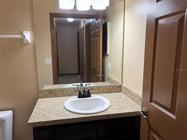 a bathroom with a granite countertop sink and a mirror