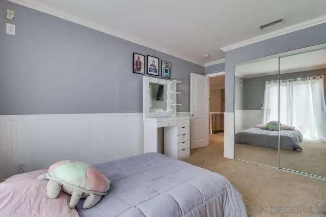 a large bed sitting in a bedroom next to a window