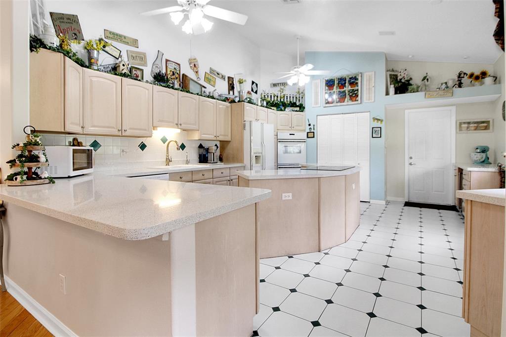 14481 Southwest 20th Street Davie, FL 33325 - Photo 14 of 36 a kitchen with a sink a stove a refrigerator and cabinets