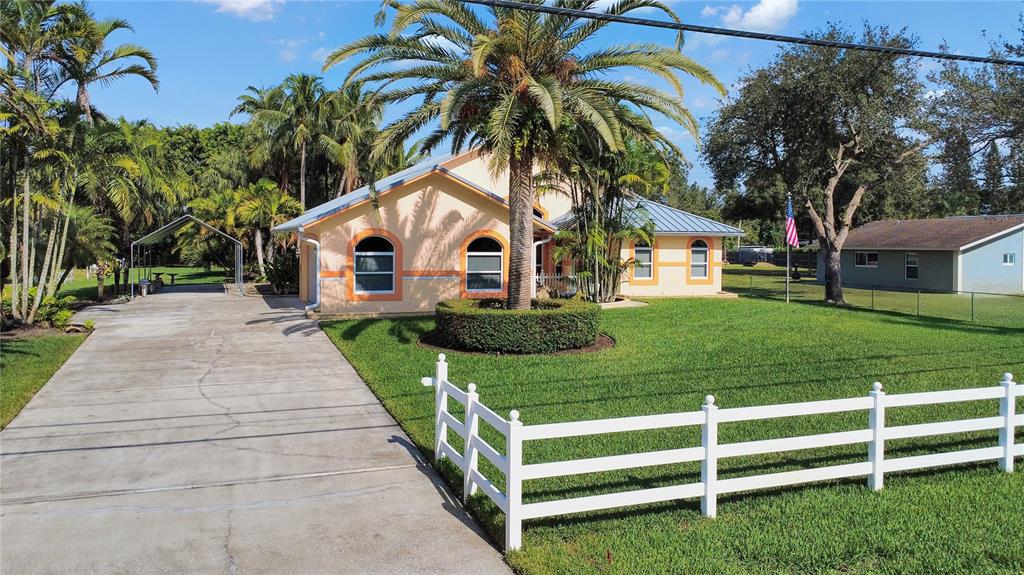 14481 Southwest 20th Street Davie, FL 33325 - Photo 2 of 36 a front view of a house with a yard and potted plants