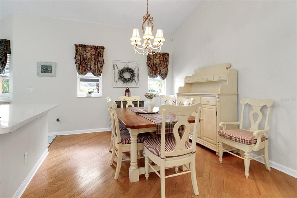 14481 Southwest 20th Street Davie, FL 33325 - Photo 21 of 36 a dining room with wooden floor a chandelier a wooden table and chairs