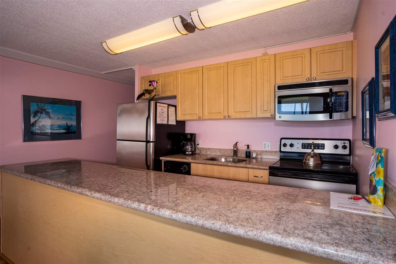 998 South Kihei Road, Unit 304 Kihei, HI 96753 - Photo 16 of 26 a kitchen with stainless steel appliances granite countertop a refrigerator a stove top oven a sink and dishwasher