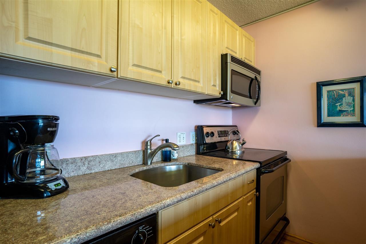 998 South Kihei Road, Unit 304 Kihei, HI 96753 - Photo 17 of 26 a kitchen with stainless steel appliances granite countertop a sink a stove and microwave