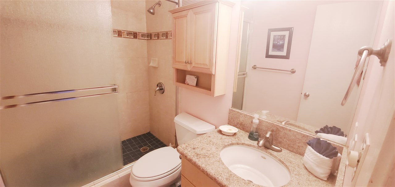 998 South Kihei Road, Unit 304 Kihei, HI 96753 - Photo 20 of 26 a white toilet sitting next to a bathroom sink and a mirror