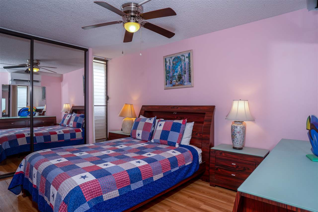 998 South Kihei Road, Unit 304 Kihei, HI 96753 - Photo 21 of 26 a bedroom with a bed and a chandelier