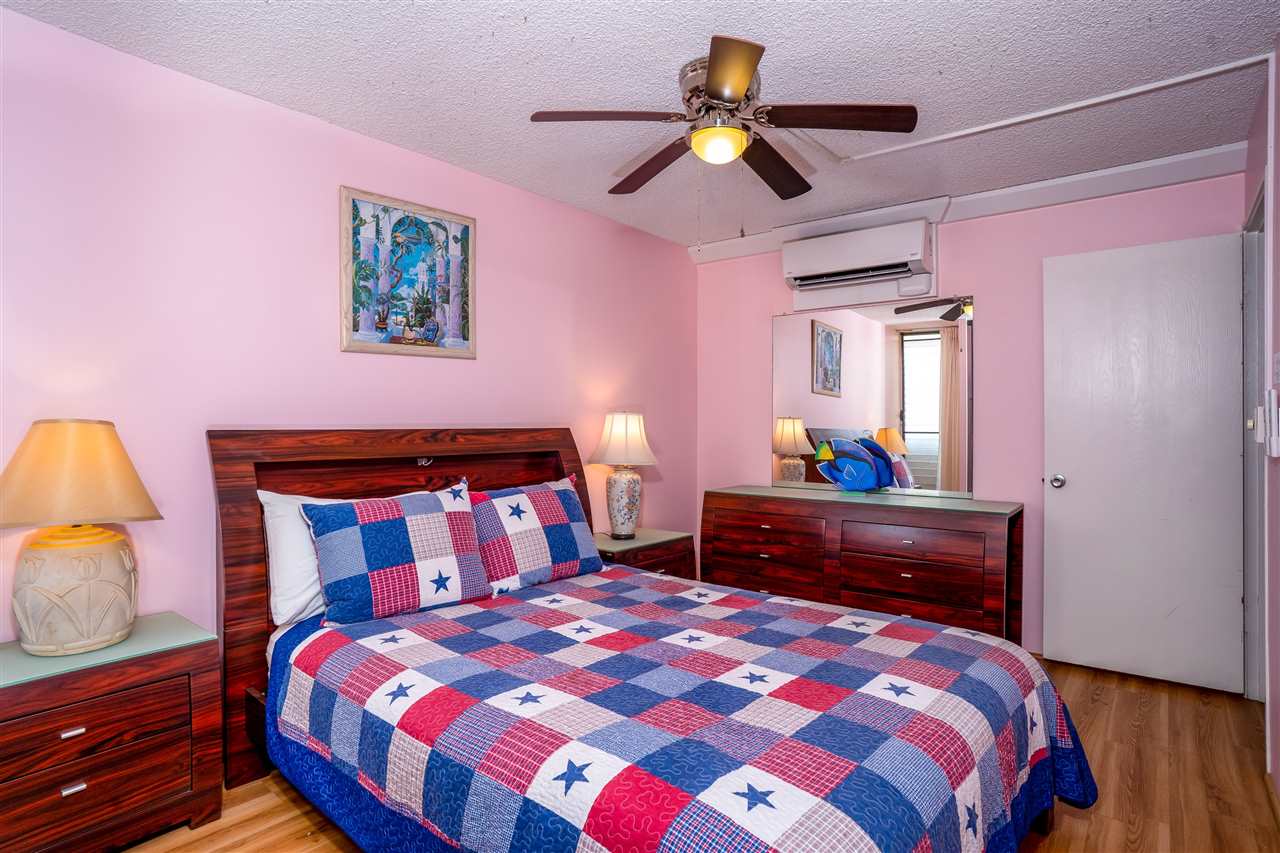 998 South Kihei Road, Unit 304 Kihei, HI 96753 - Photo 22 of 26 a bedroom with a bed and a chandelier