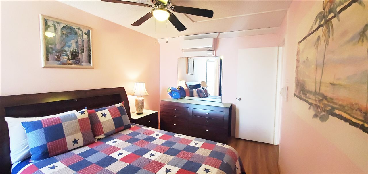 998 South Kihei Road, Unit 304 Kihei, HI 96753 - Photo 23 of 26 a bedroom with a bed and wooden floor