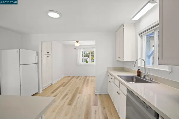 a view of a kitchen sink and refrigerator