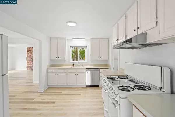 a kitchen with white cabinets and appliances