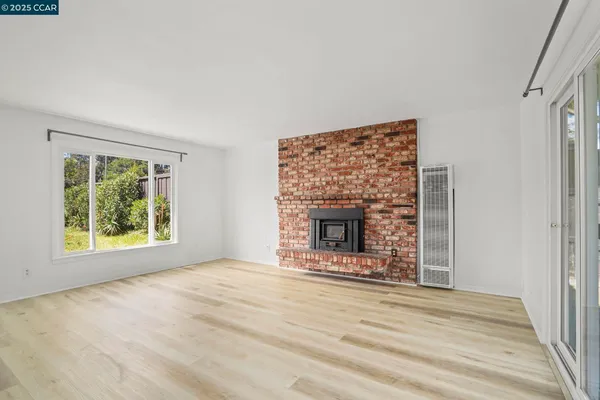 an empty room with a fireplace and window