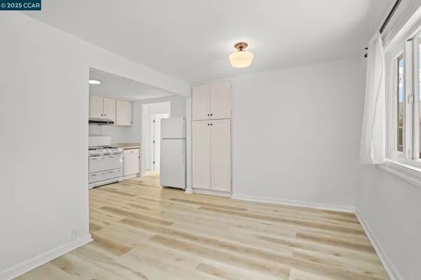 a view of empty room with wooden floor and window