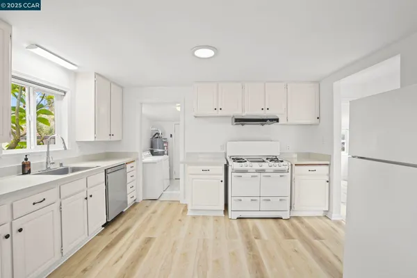 a kitchen with white cabinets and white appliances