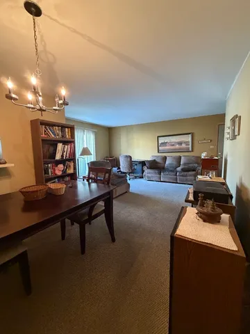 a living room with furniture a chandelier and a flat screen tv