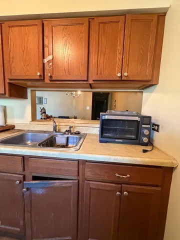 a kitchen with a sink a microwave cabinets and utility