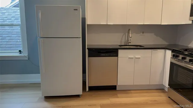 a kitchen with a refrigerator sink and cabinets