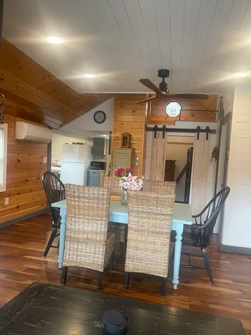 a dining room with furniture a chandelier and wooden floor