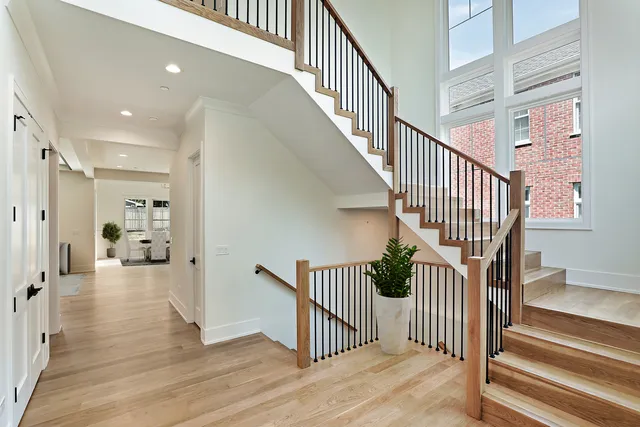 a kitchen with stainless steel appliances granite countertop a sink a stove a refrigerator and island with wooden floor