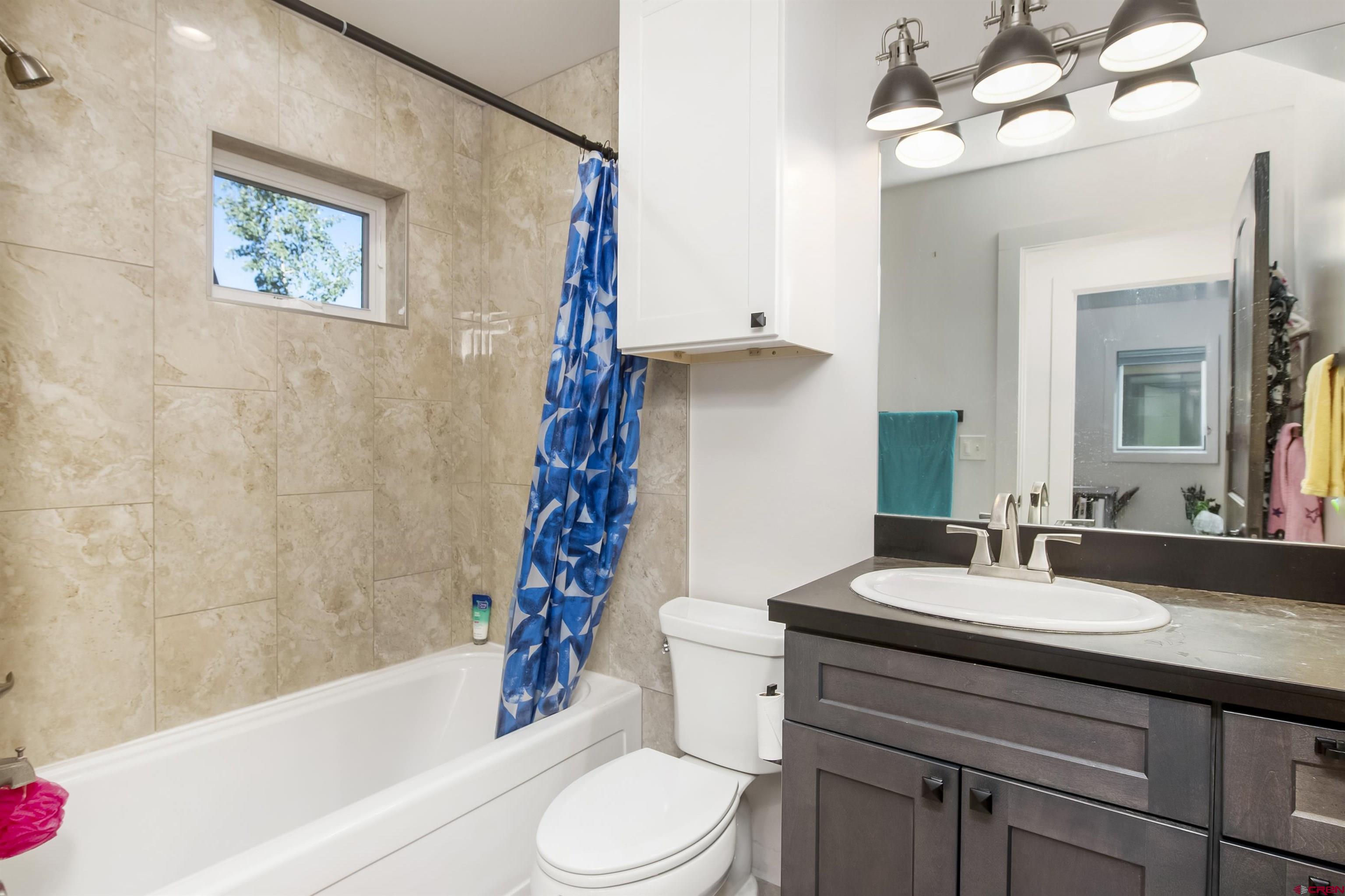 363 Cement Creek Road, Unit 3 Crested Butte, CO 81224 - Photo 15 of 34 a bathroom with a sink a toilet a mirror a bathtub and shower
