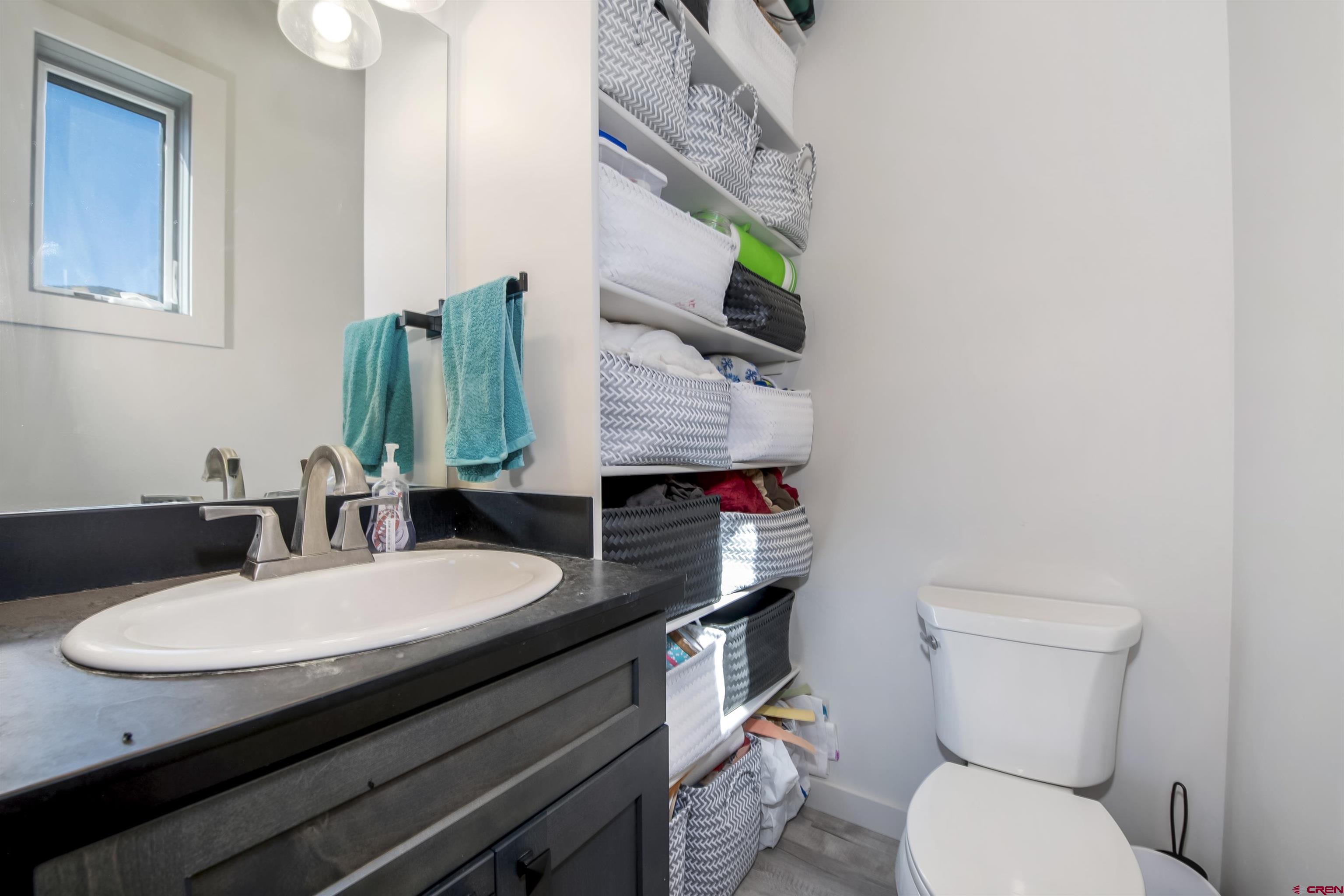 363 Cement Creek Road, Unit 3 Crested Butte, CO 81224 - Photo 16 of 34 a bathroom with a granite countertop toilet sink and mirror