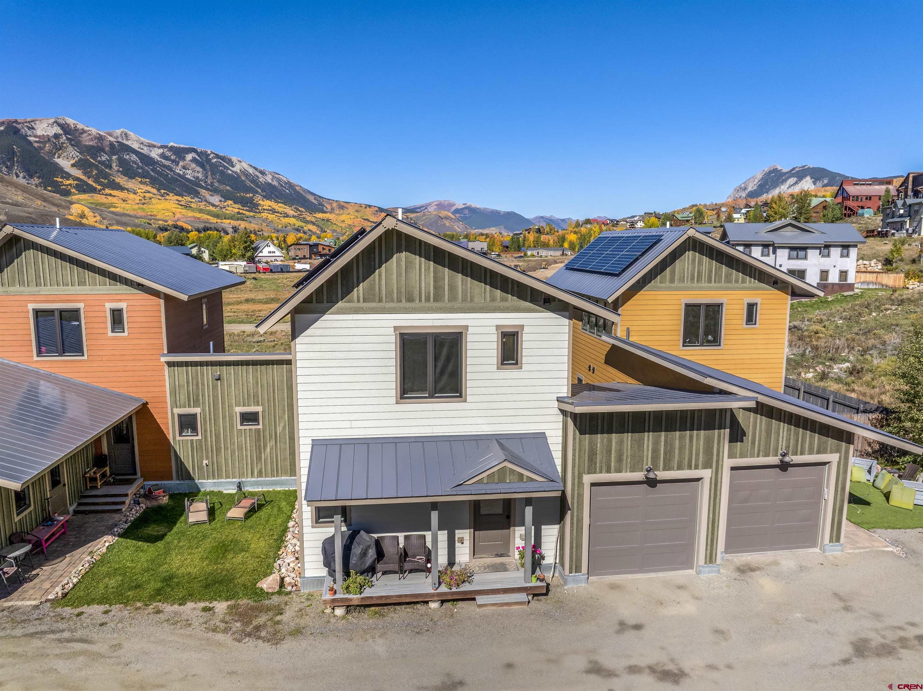 363 Cement Creek Road, Unit 3 Crested Butte, CO 81224 - Photo 29 of 34 a view of a white house with a small yard and large trees