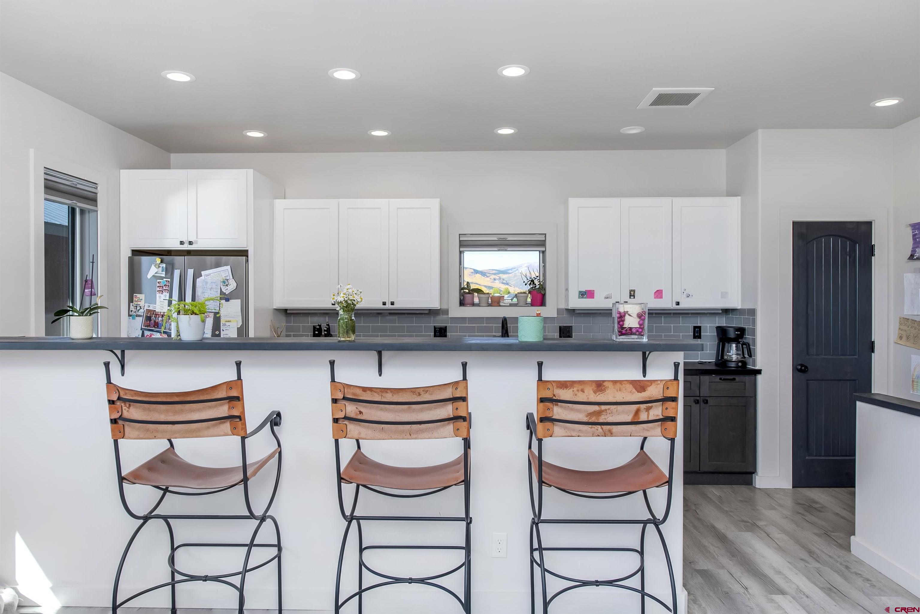 363 Cement Creek Road, Unit 3 Crested Butte, CO 81224 - Photo 5 of 34 a kitchen with stainless steel appliances a white table and chairs in it