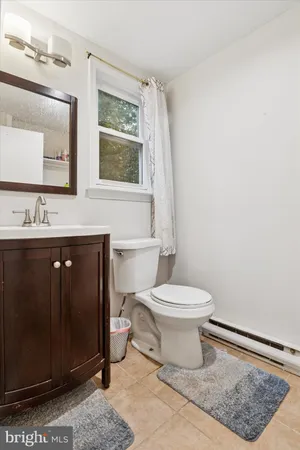 a bathroom with a toilet a sink a vanity and mirror