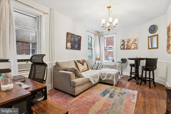 a living room with furniture a dining table and a chandelier