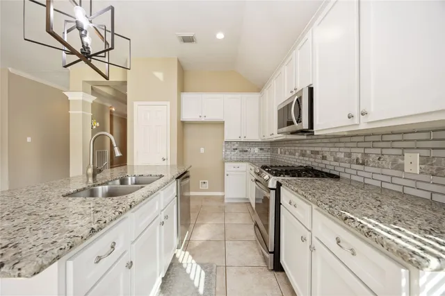 a kitchen with stainless steel appliances granite countertop a sink stove and cabinets