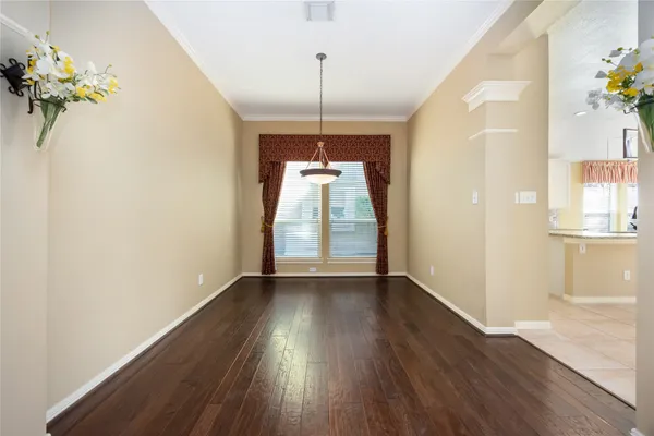 a view of a room with wooden floor potted plant and a chandelier