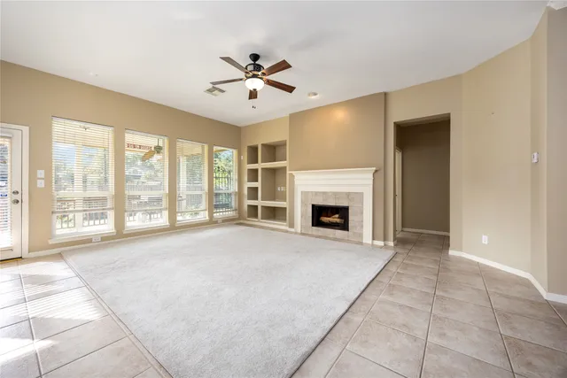 a view of an empty room with a fireplace and a window