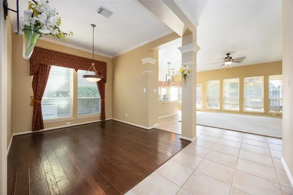 a view of an empty room with a window and wooden floor