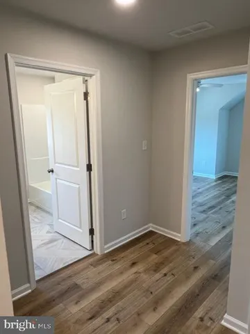 an empty room with wooden floor and entrance