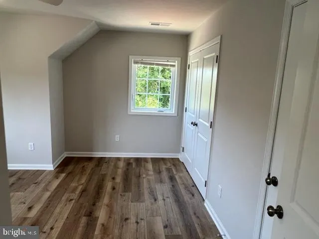 a view of a room with wooden floors and window