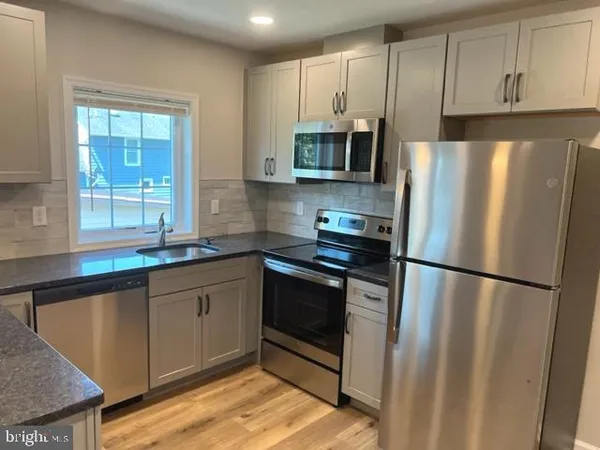 a kitchen with stainless steel appliances granite countertop a refrigerator sink and microwave