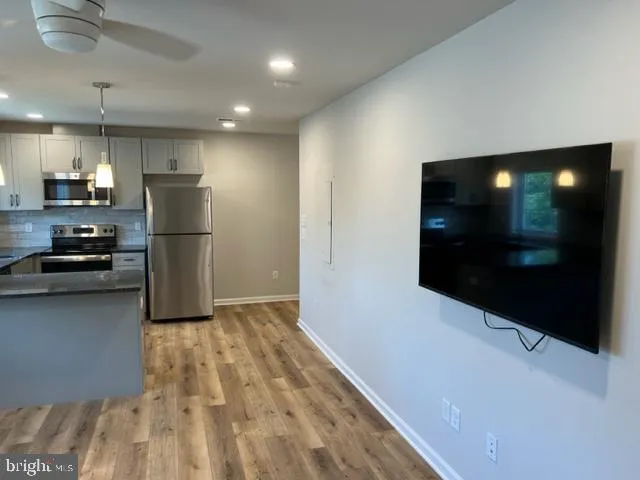a kitchen with a refrigerator and a stove top oven