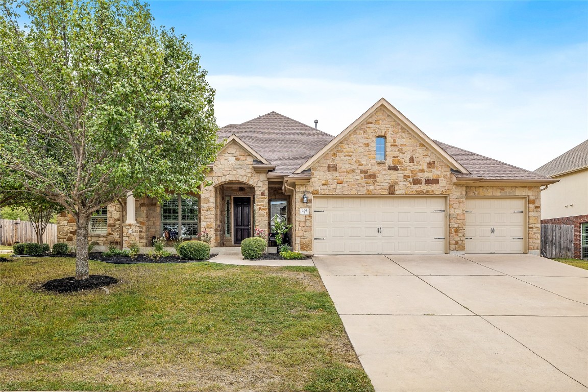 a view of a white house with a small yard and large trees