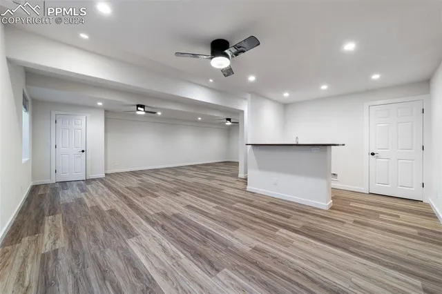 a kitchen with kitchen island a sink wooden floor and a window