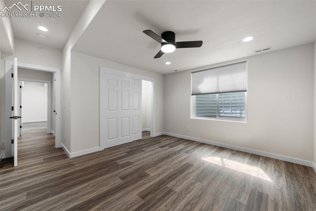 38640 Jones Road Rush, CO 80833 - Photo 32 of 41 an empty room with wooden floor a ceiling fan and windows