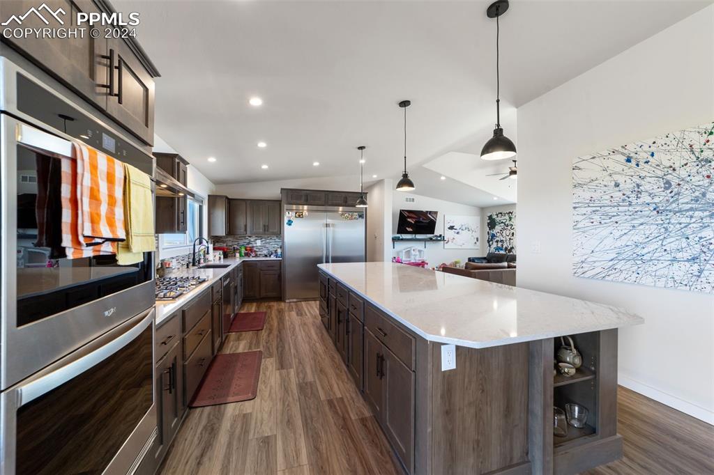38640 Jones Road Rush, CO 80833 - Photo 9 of 41 a large kitchen with stainless steel appliances kitchen island granite countertop a sink a counter space and wooden floor