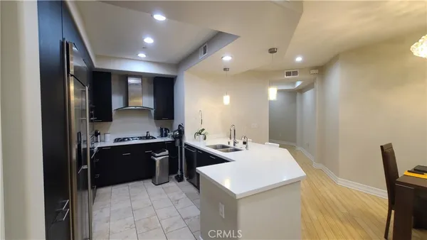 a large kitchen with stainless steel appliances a sink and a refrigerator