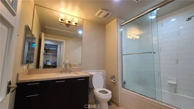 a bathroom with a sink a toilet a large mirror and shower